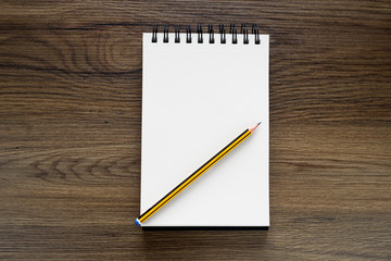 School notebook with pencil on vintage wooden table.