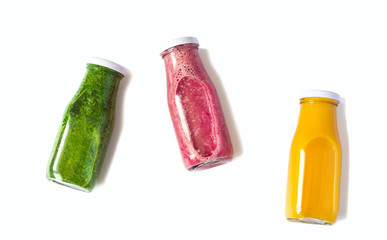 Colorful smoothies in bottles isolated on white background, top view. Natural Organic Food Style.