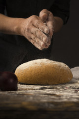 Fototapeta premium Conceptual art photography of a old woman hands drops hands, pour flour on bread