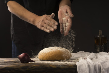 Conceptual art photography of a old woman hands drops hands, pour flour on bread