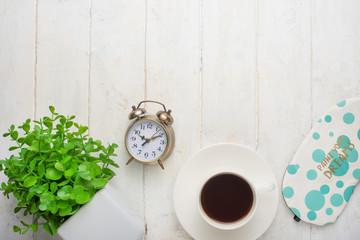 Alarm clock, coffee and flowers. Morning mood, on a white background, top view, with a blank space for an inscription or advertisement.