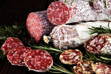 thinly sliced salami on a wooden texture on the background.