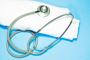 Stethoscope with white shirt on blue background.