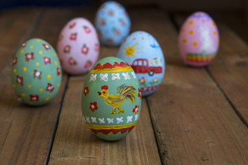 Easter egg with a cockerel on a wooden board