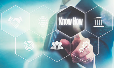 A businessman's hand selecting a Know How concept button on a futuristic computer screen.