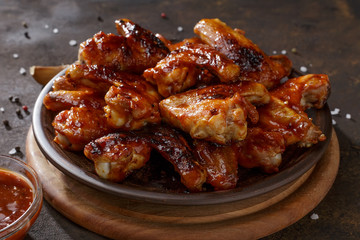 Grilled chicken wings with bbq sauce on the clay plate on the table. - 198360821