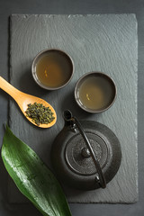 Green japanese tea on black slate background. Top view with copy space.