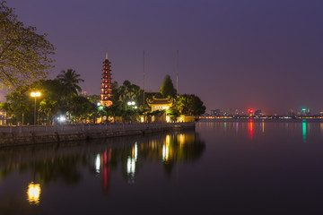 Fototapeta premium Beautiful night view of the Tran Quoc Pagoda on the small peninsula (The most ancient pagoda in Hanoi, originally constructed in the 6th century), East side of West Lake, Hanoi, Vietnam