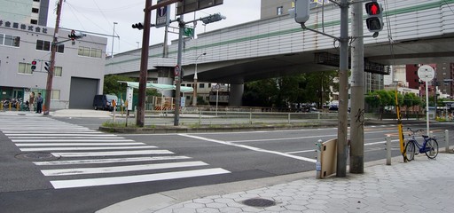 Osaka City Center - Quiet grey cityscape of a residential part of downtown city center Osaka in Japan (Asia) with houses, a crosswalk, traffic lights and a bridge
