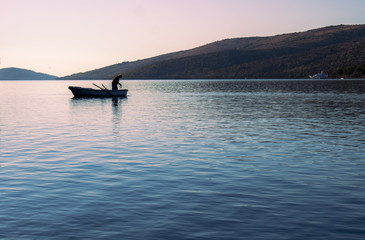 Fototapeta premium The fisherman on the old boat is hunting fish