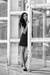 Obraz premium beautiful girl in a dress on the background of a glass metal construction