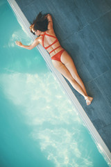 Young woman lying by swimming pool