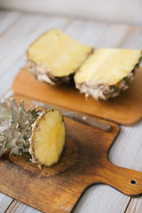 Sliced fresh pineapple on a wooden background in sunlight