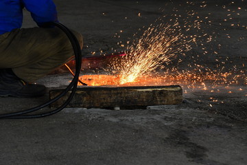 Industrial Worker. Welder-carver at the production of gas-welding with sparks.