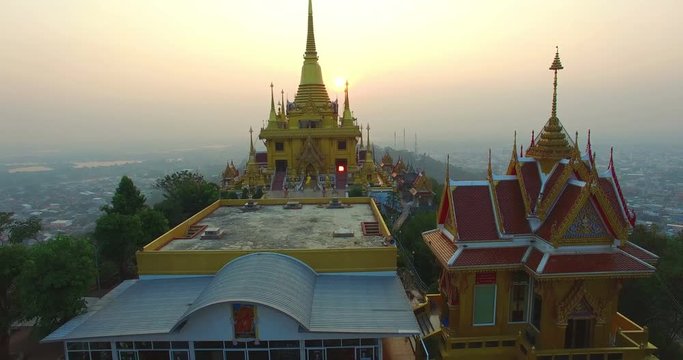 aerial photography sunrise around the golden pagoda of Kiriwong temple on the high mountain. Wat Kiriwong is the most beautiful temple in Pak Nam Pho Nakorn Sawan province Thailand