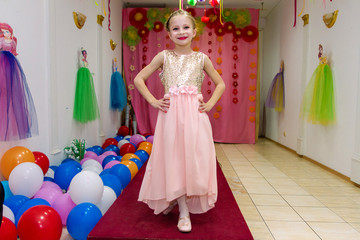 Happy beautiful little girl shows dress and having fun