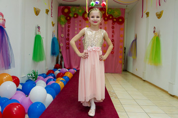 Happy beautiful little girl shows dress and having fun