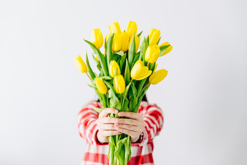 woman hold bouquet of yellow tulips. cover face with flowers. spring romantic concept