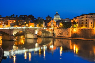 Fototapeta na wymiar Victor Emmanuel bridge over Tiber river with St. Peter's Cathedral as background at night, Rome, Italy