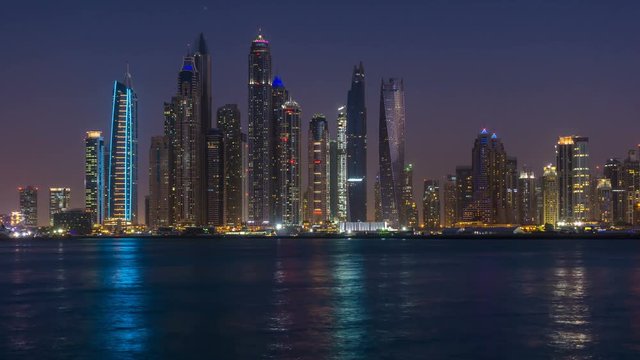Dusk to night transition of Dubai Marina cityscape, View from Palm Jumeirah, time lapse, United Arab Emirates.