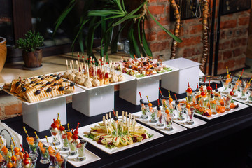 A table with catering. - obrazy, fototapety, plakaty