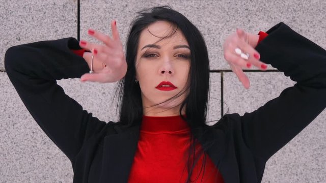 Sexy female dancer in Vogue and Waacking dance style dancing in the city with urban background.