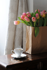 Cup of coffee and beautiful tulips