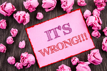 Handwriting text showing It Is Wrong. Business photo showcasing Correct Right Decision To Make Or Mistake Advice written on Pink Sticky Note Paper Folded Paper on wooden background