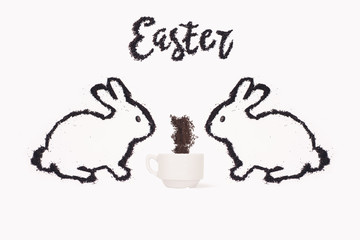 Two Easter bunny from coffee ground with cup of coffee on a white background