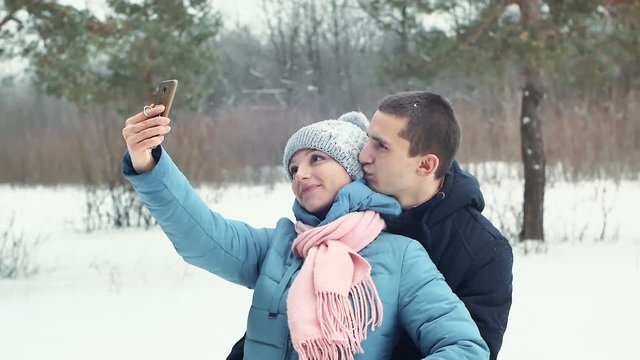 romantic couple in the forest taking a selfie, winter