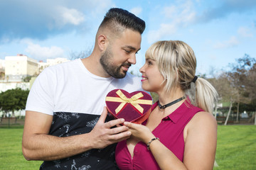 Couple in love with a gift in the form of heart.