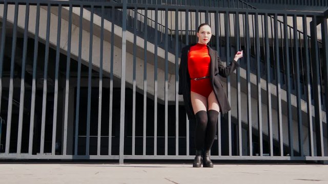 Sexy female dancer in Vogue and Waacking dance style dancing in the city with urban background.