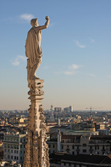 Fototapeta premium Statue with raised hand on the cathedral of Milan, Italy