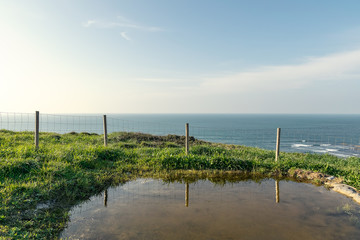 Fototapeta premium pond fenced with the sea in the background on the horizon.