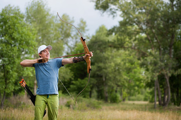 Man shoots an arrow in the forest on vacation