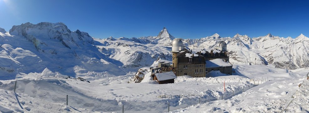 Panorama Foto vom Gornergrat mit dem Observatorium KOSMA und TIRGO, im Hintergrund das Matterhorn, links das Breithorn und das Klein Matterhorn im Winter
