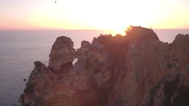 Aerial view of cliffs on the ocean shore at sunset