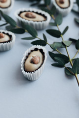 Composition of delicious praline sweets with almonds on blue background