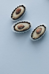 Composition of delicious praline sweets with almonds on blue background
