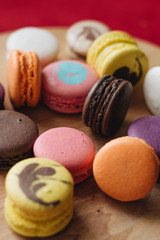 Composition of delicious colorful macaroons on wooden board, sweet dessert