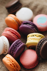 Composition of delicious colorful macaroons on wooden board, sweet dessert