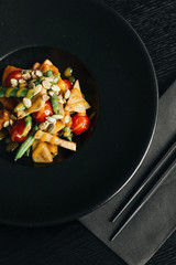 Fresh healthy dinner with seeds and vegetables on black plate