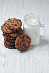 oatmeal cookies with chocolate and milk on a white background