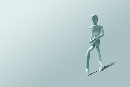 Wooden mannequin in a running pose. Blue Wooden model in a run. Morning running, training. Jogging. The figure of wood runs on a pastel blue background. Caring for physical condition.