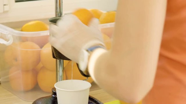 Refreshment drink. Close-up shot of juicer making fresh orange juice. 4K