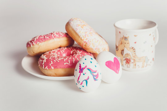 Easter eggs with donuts on the white table