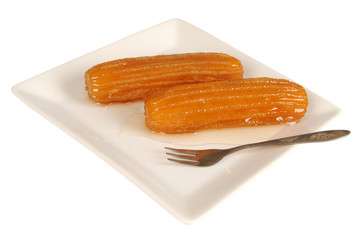 Traditional Turkish dessert tulumba on plate with fork