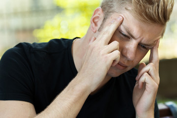 Portrait of a pretty man  stress and headache having migraine pain