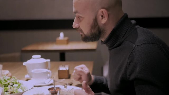 white man is eating dinner in a restaurant