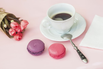 Obraz na płótnie Canvas Pink and vioet macarons, macaroons, spring flowers, top view. Romantic morning, gift for beloved. Breakfast on Valentin's, Mothers, Women's day. Tender background.